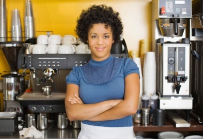 Woman standing beside espresso machine