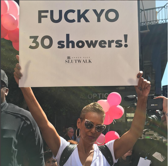 Amber Rose's mom pictured with a sign that takes a stance against a shaming statement made towards Rose by Kanye West earlier this year