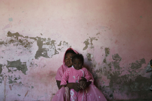 A sheedi women sits in her house with her baby. Hyderabad, Pakistan.
