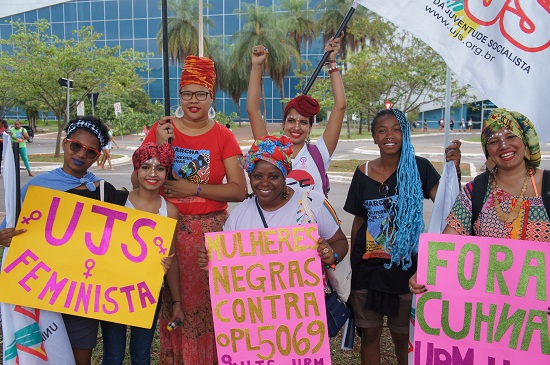 Young activists hold signs saying “Black Women Against PL 5069/13”, detesting a law proposed by Mayor Eduardo Cunha (PMDB-RJ), which would require rape victims to prove that they have been raped in order qualify for a legal abortion. Source