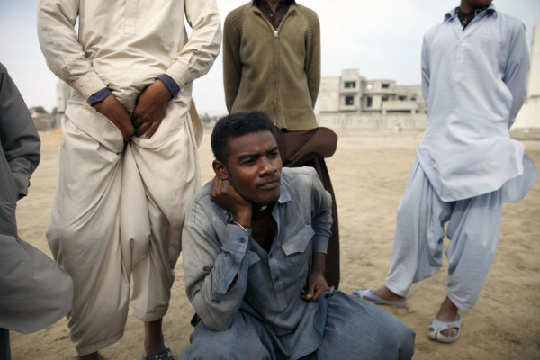 Sheedi men have a break after playing cricket. Hyberabad, Pakistan